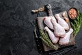Fresh Raw chicken drumsticks legs on wooden cutting board. Black background. Top view. Copy space Royalty Free Stock Photo