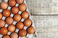 Fresh raw chicken eggs in carton egg box on wood table Royalty Free Stock Photo