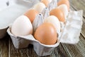 Fresh raw chicken eggs in carton egg box on wooden background. Royalty Free Stock Photo