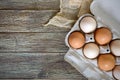 Fresh raw chicken eggs in carton egg box on wooden background. Royalty Free Stock Photo