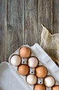 Fresh raw chicken eggs in carton egg box on wooden background. Royalty Free Stock Photo