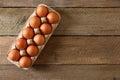 Fresh raw chicken eggs in carton on wooden table, top view. Space for text Royalty Free Stock Photo