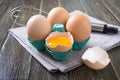 Fresh raw chicken eggs in an cartons egg box. Broken egg, yolk. Organic food for good health high protein on rustic wooden