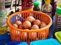 Fresh Raw Chicken Eggs in Orange Plastic Basket in Kitchen Royalty Free Stock Photo