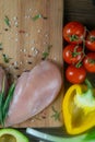 Fresh raw chicken fillet and vegetables prepared for cooking. Tomatoes and bell peppers top views with clear space Royalty Free Stock Photo