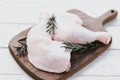 Fresh raw chicken leg fillet on wooden cutting board background - chicken meat with rosemary Royalty Free Stock Photo