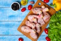 Fresh raw chicken legs on a cutting board with vegetables and spices on wooden background Royalty Free Stock Photo