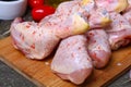 Fresh raw chicken legs on a cutting board with vegetables and spices on wooden background Royalty Free Stock Photo