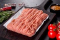 Fresh raw chicken mince on a dark wooden cutting board