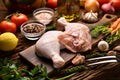 Fresh raw chicken thighs with ingredients for cooking on a wooden cutting board Royalty Free Stock Photo