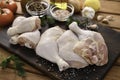 Fresh raw chicken thighs with ingredients for cooking on a wooden cutting board Royalty Free Stock Photo