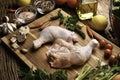 Fresh raw chicken thighs with ingredients for cooking on a wooden cutting board Royalty Free Stock Photo