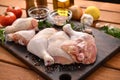 Fresh raw chicken thighs with ingredients for cooking on a wooden cutting board Royalty Free Stock Photo