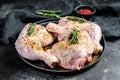 Fresh raw chicken thighs, legs on a cutting Board with spices, cooking. Black background. Top view Royalty Free Stock Photo