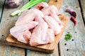 Fresh raw chicken wings with garlic, onion and peppers on a cutting board