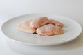 Fresh raw chicken wings on white dish with white background