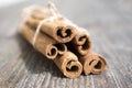 Fresh raw cinnamon sticks on wooden table tied with jute natural twine