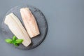 Fresh raw cod fillet with basil on stone plate, horizontal, copy