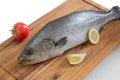 Fresh raw corvina fish isolated on wooden chopping board