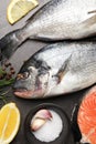 Fresh raw dorado fish, spices and lemon slices on grey table, flat lay