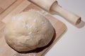 Fresh raw dough on wooden board, rolling pin, homemade pizza dough, homemade whole wheat bread Royalty Free Stock Photo