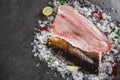 Fresh raw fillet fish and whole fish with spices on ice over dark stone background. Seafood, top view, flat lay Royalty Free Stock Photo