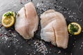 Fresh raw fillet white fish Pangasius with spices and lemon on dark stone background. Royalty Free Stock Photo