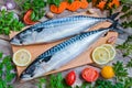 Fresh raw fish mackerel and ingredients for cooking on a wooden background Royalty Free Stock Photo