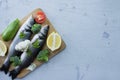 Fresh raw fish sea bass on cutting board, raw vegetables, spices and nuts. Stone background. Royalty Free Stock Photo