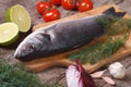 Fresh raw fish sea bass on a cutting board with vegetables Royalty Free Stock Photo