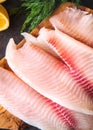 Fresh raw fish tilapia fillet on a board, close-up view Royalty Free Stock Photo