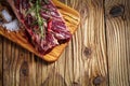 Fresh raw flank steak on the very nice rustikal wooden plate. Old wooden background with copy space for text Royalty Free Stock Photo