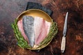 Fresh Raw Gilthead Sea bream fish fillets ready for cooking. Dark background. Top view