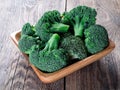 Fresh raw green broccoli in wooden bowl on wooden background Royalty Free Stock Photo