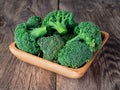 Fresh raw green broccoli in wooden bowl on wooden background Royalty Free Stock Photo