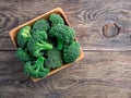 Fresh raw green broccoli in wooden bowl on wooden background, to Royalty Free Stock Photo