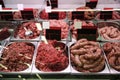 Fresh raw ground meat and sausages in refrigerator at market Royalty Free Stock Photo