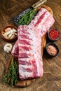 Fresh Raw lamb rack spare ribs with spices on a cutting board. Wooden background. Top view Royalty Free Stock Photo