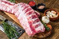 Fresh Raw lamb rack spare ribs with spices on a cutting board. Wooden background. Top view Royalty Free Stock Photo