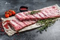 Fresh raw lamb spare ribs with spices and herbs. Black background. Top view Royalty Free Stock Photo