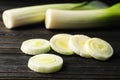 Fresh raw leek on black wooden table, closeup. onion