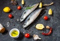 Fresh raw mackerel with lemon and spices on black stone background. Royalty Free Stock Photo