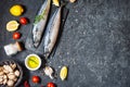 Fresh raw mackerel with lemon and spices on a black stone background. Top view Royalty Free Stock Photo