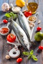 Fresh raw mackerel with lemon, tomatoes and spices on parchment. Preparing to bake