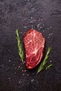 Fresh raw marbled beef rib eye steak and spices on black stone background Royalty Free Stock Photo