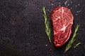 Fresh raw marbled beef rib eye steak and spices on black stone background, copy space Royalty Free Stock Photo
