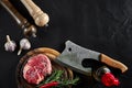 Piece of beef tenderloin, with ax for cutting and chopping meat, spices were cooking - rosemary, pepper, salt, garlic