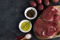 Fresh raw meat beef steak olive oil Uncooked potato Spices Salt Wooden spoon Chili Pepper Rosemary Royalty Free Stock Photo