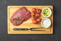 Fresh raw meat beef steak on wooden cutting board with ingredients for cooking Royalty Free Stock Photo