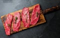 Fresh raw meat beef steaks. Beef tenderloin on wooden board, spices, herbs, oil on slate gray background. Food cooking background Royalty Free Stock Photo